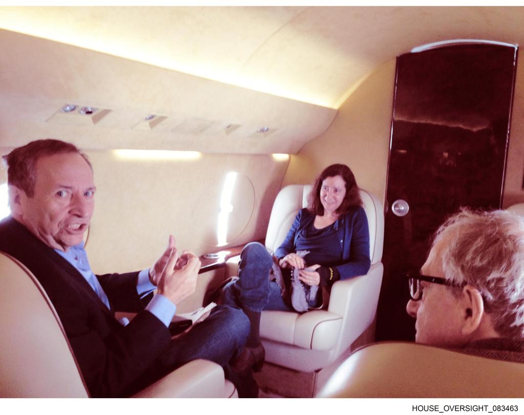 Former United States Secretary of the Treasury (left) speaks with an unknown woman and director Woody Allen on a plane.